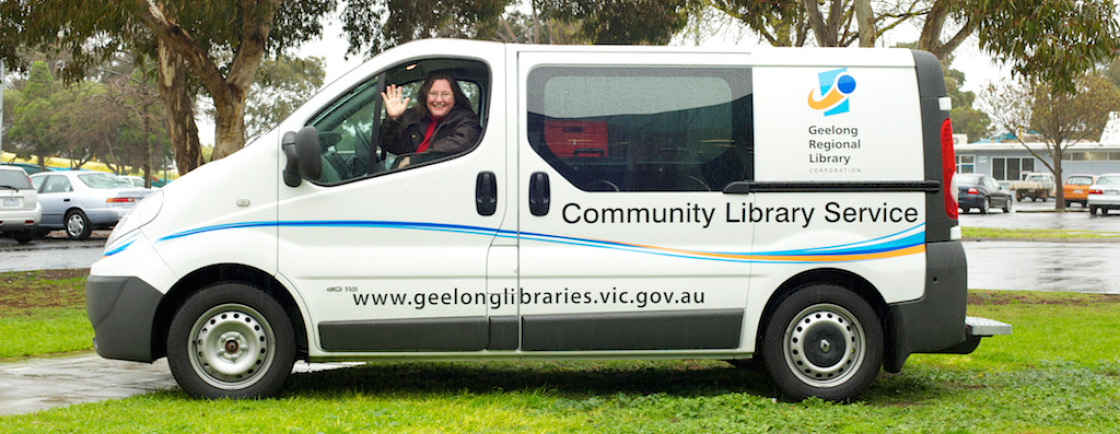 Mobile library van parked in grassy area under a tree